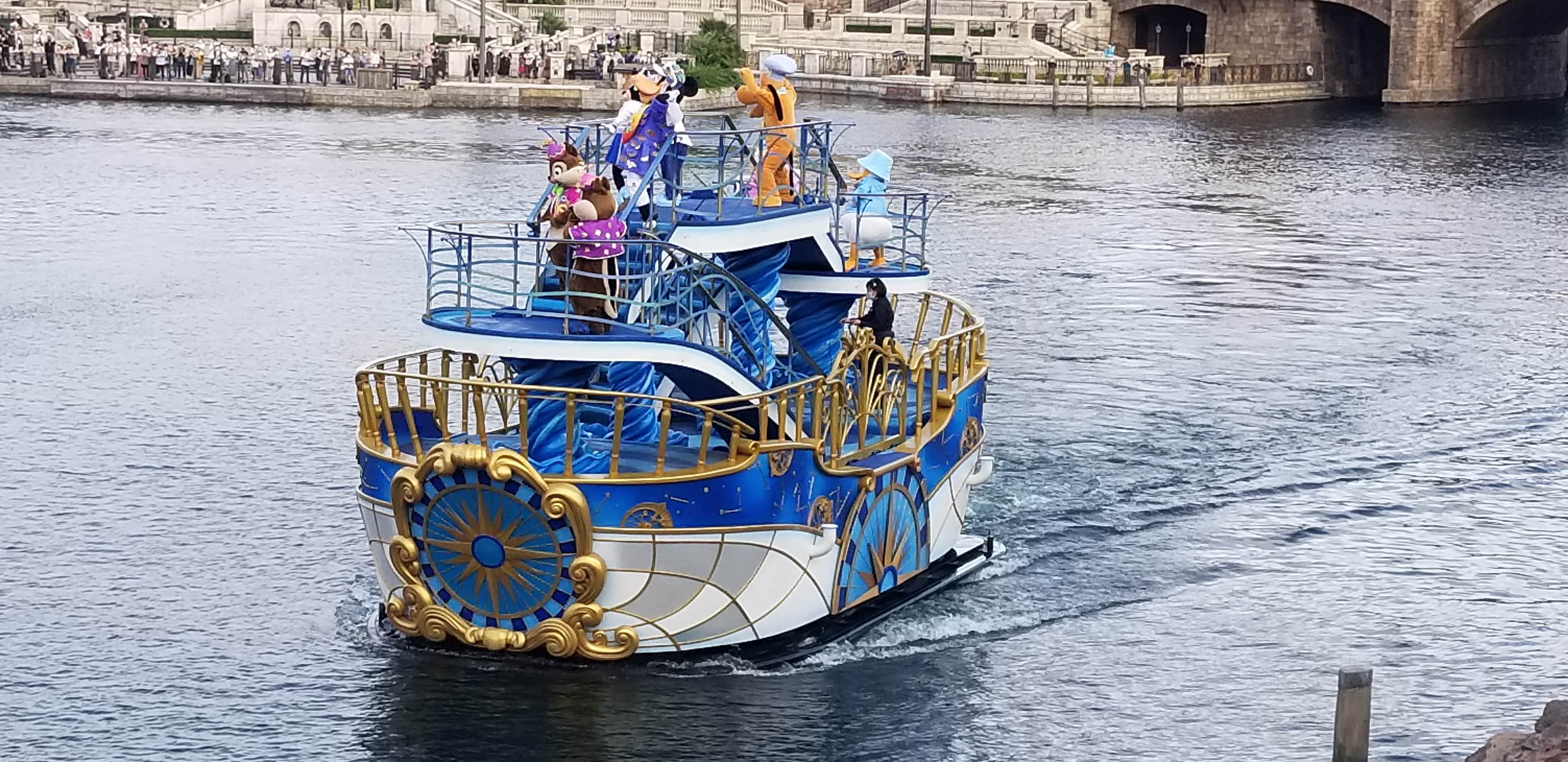 Water parade boat with Mickey, Goofy, Pluto, Chip and Dale sailing through the Mediterranean Harbor