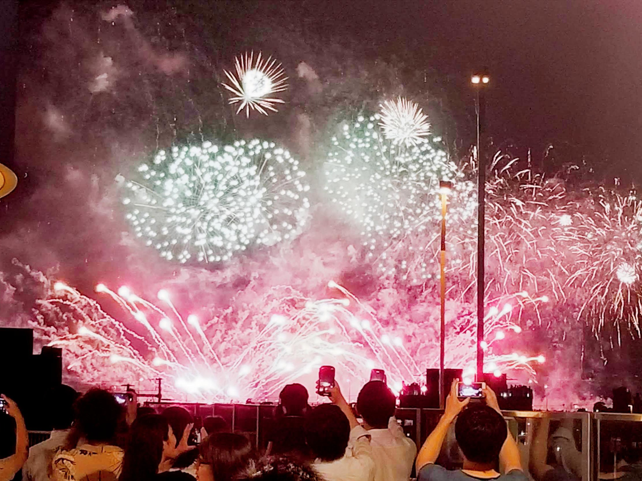 Hanabi de verano en Japón: fuegos artificiales en pleno apogeo con el público fotografiando el espectáculo