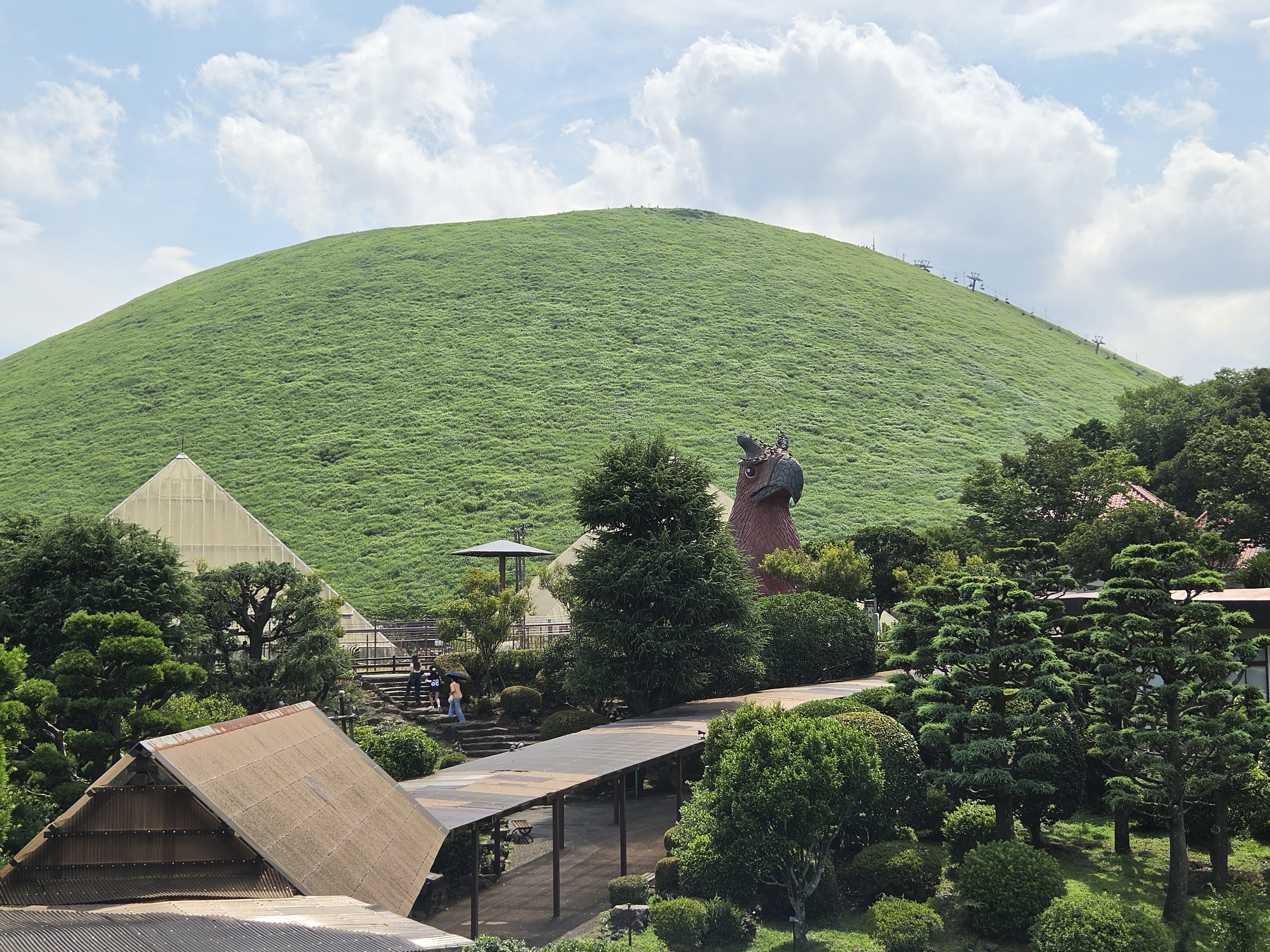 View of Omuroyama from Izu Shaboten Park, the perfectly round grass-covered volcano with park facilities in the foreground