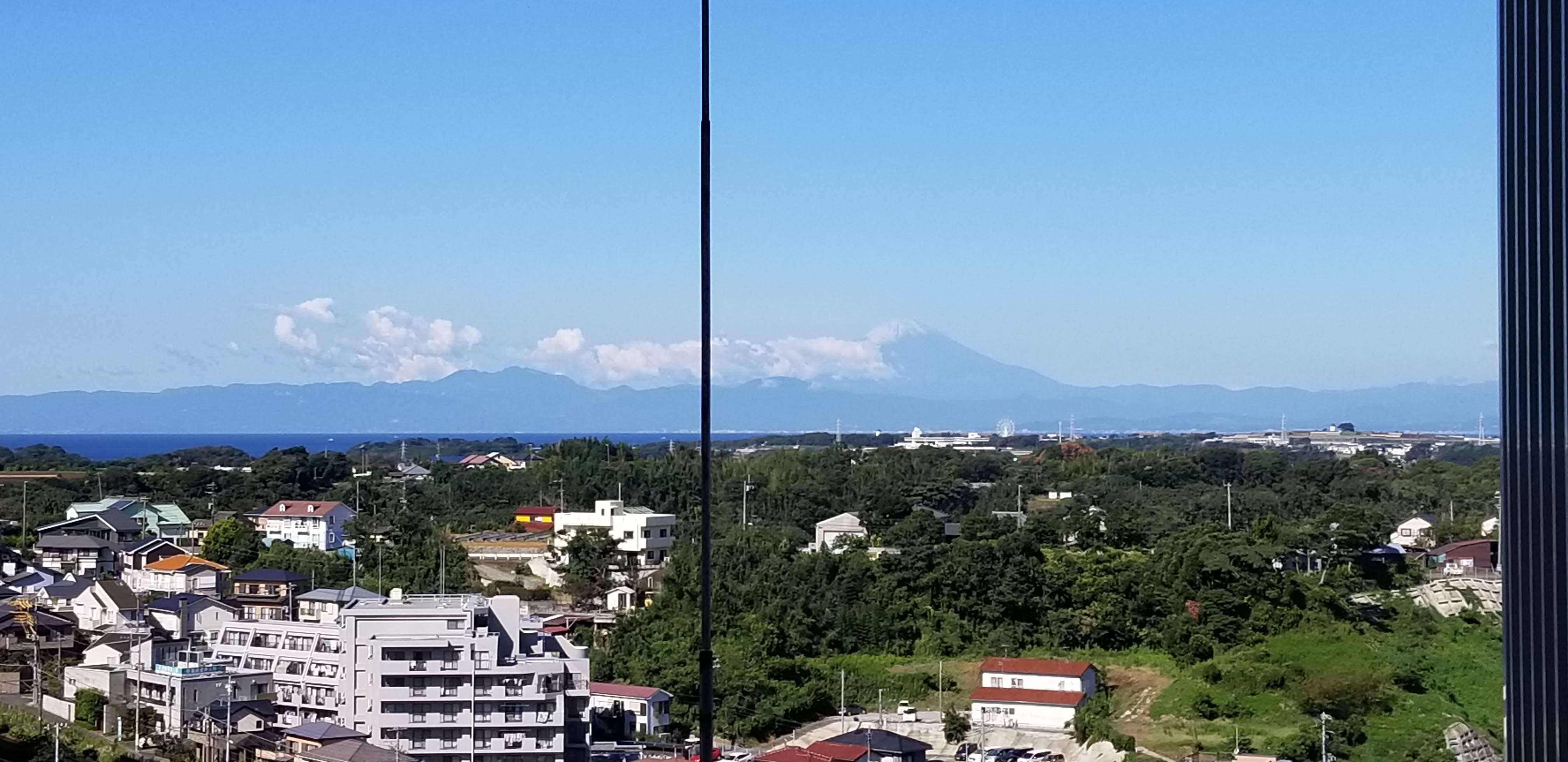 View from the room towards Mount Fuji, partly clouded, with Miura city and the sea in the foreground, September morning