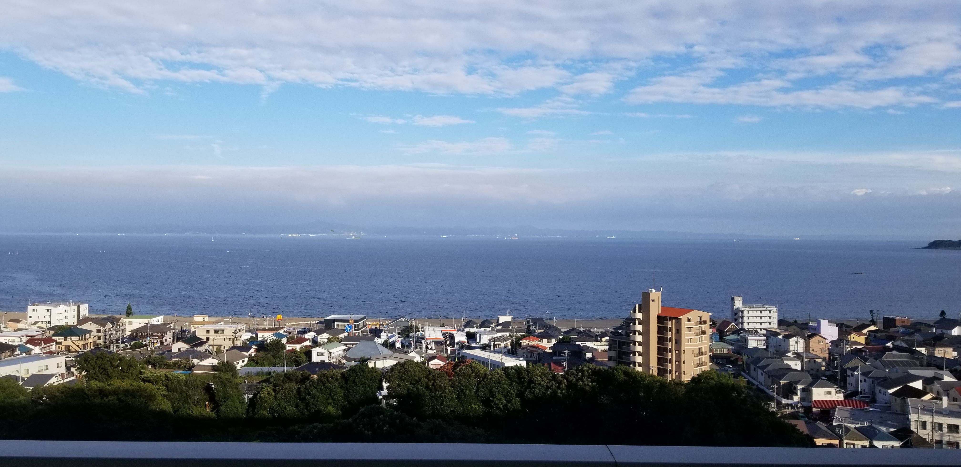 View from a Mahoroba Minds room: panorama of Miura city with Sagami Bay in the background, September afternoon