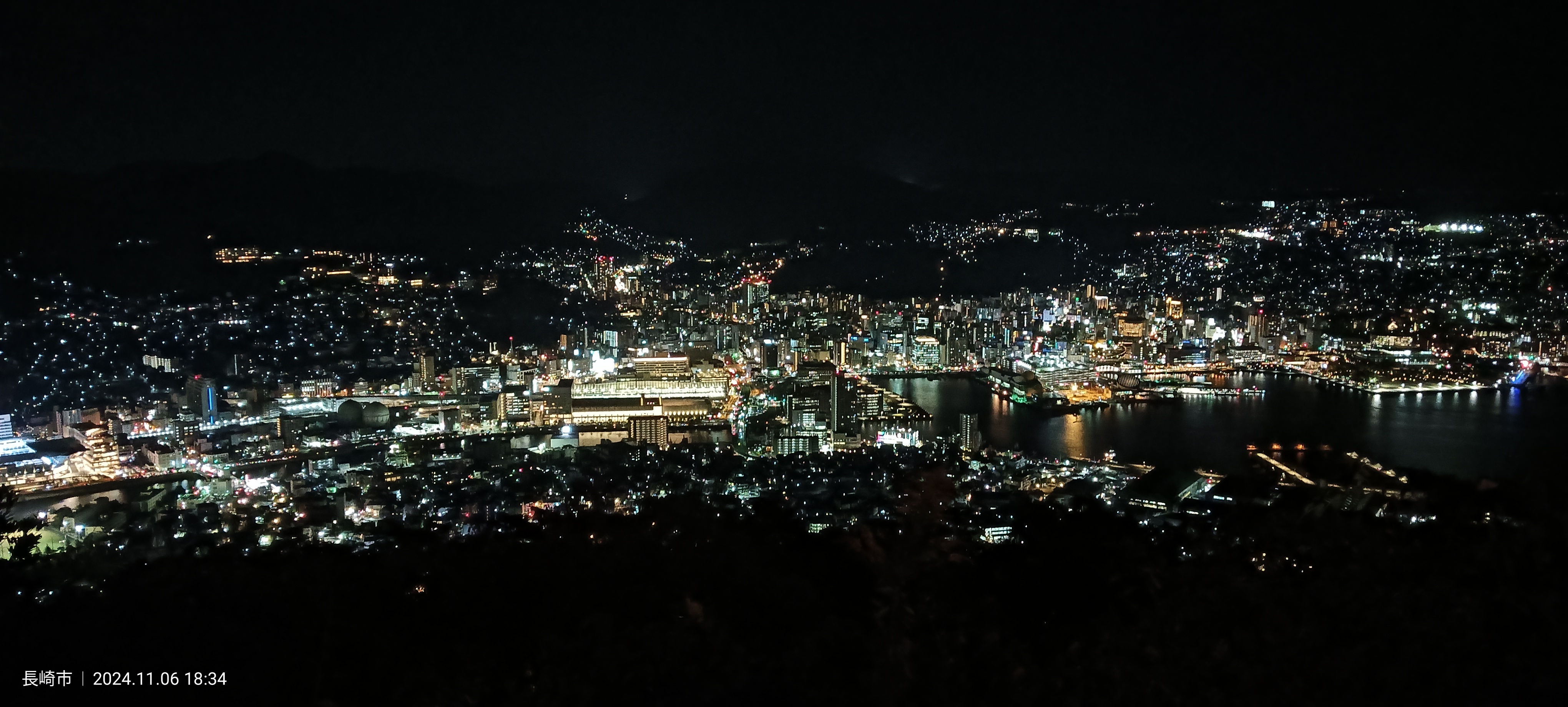 Vista panorámica nocturna de Nagasaki desde el Monte Inasa: el puerto y la ciudad iluminados rodeados de colinas
