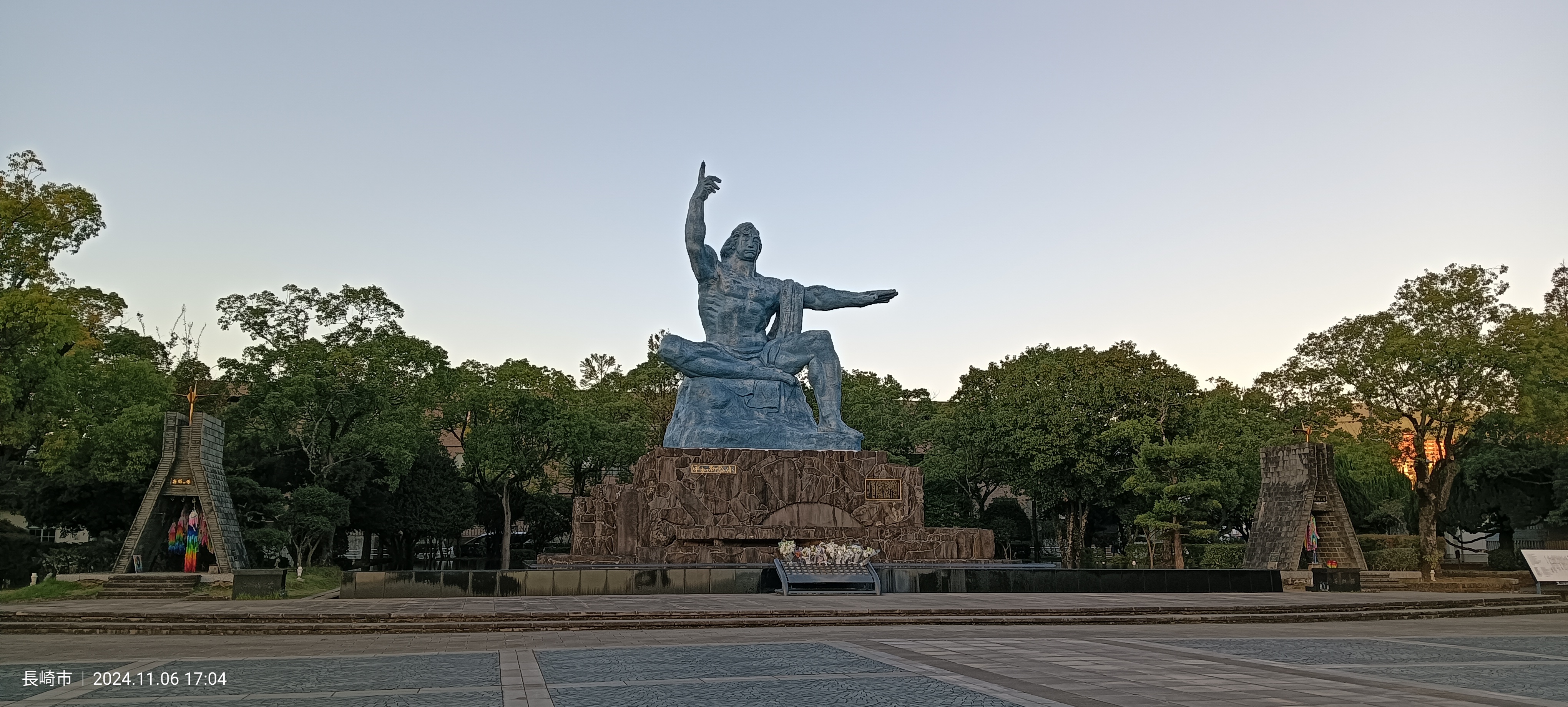 La Estatua de la Paz en el Parque de la Paz de Nagasaki, con el brazo derecho apuntando al cielo y el brazo izquierdo horizontal señalando el horizonte