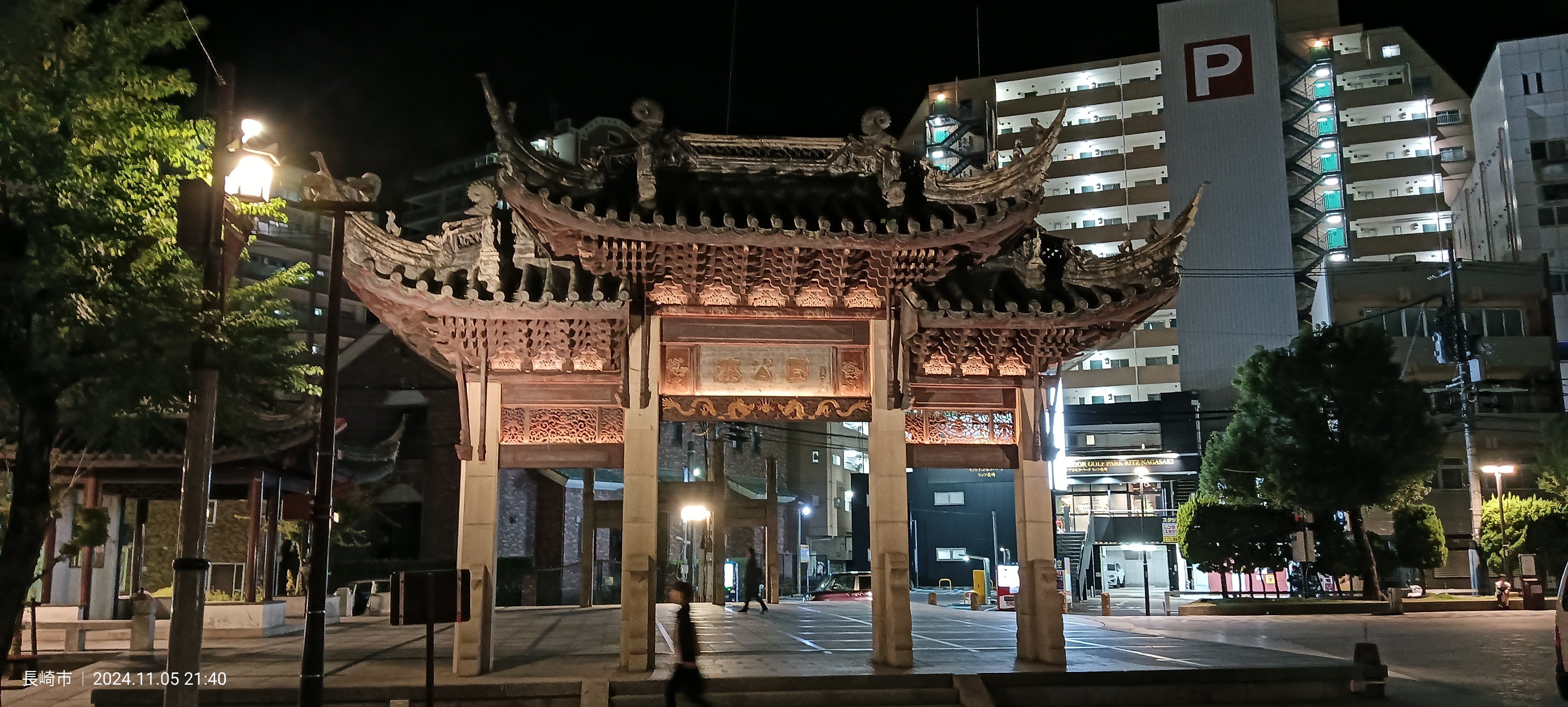 La puerta de entrada al barrio chino de Nagasaki (Shinchi) iluminada de noche, con tejado de estilo chino y decoración en rojo y dorado