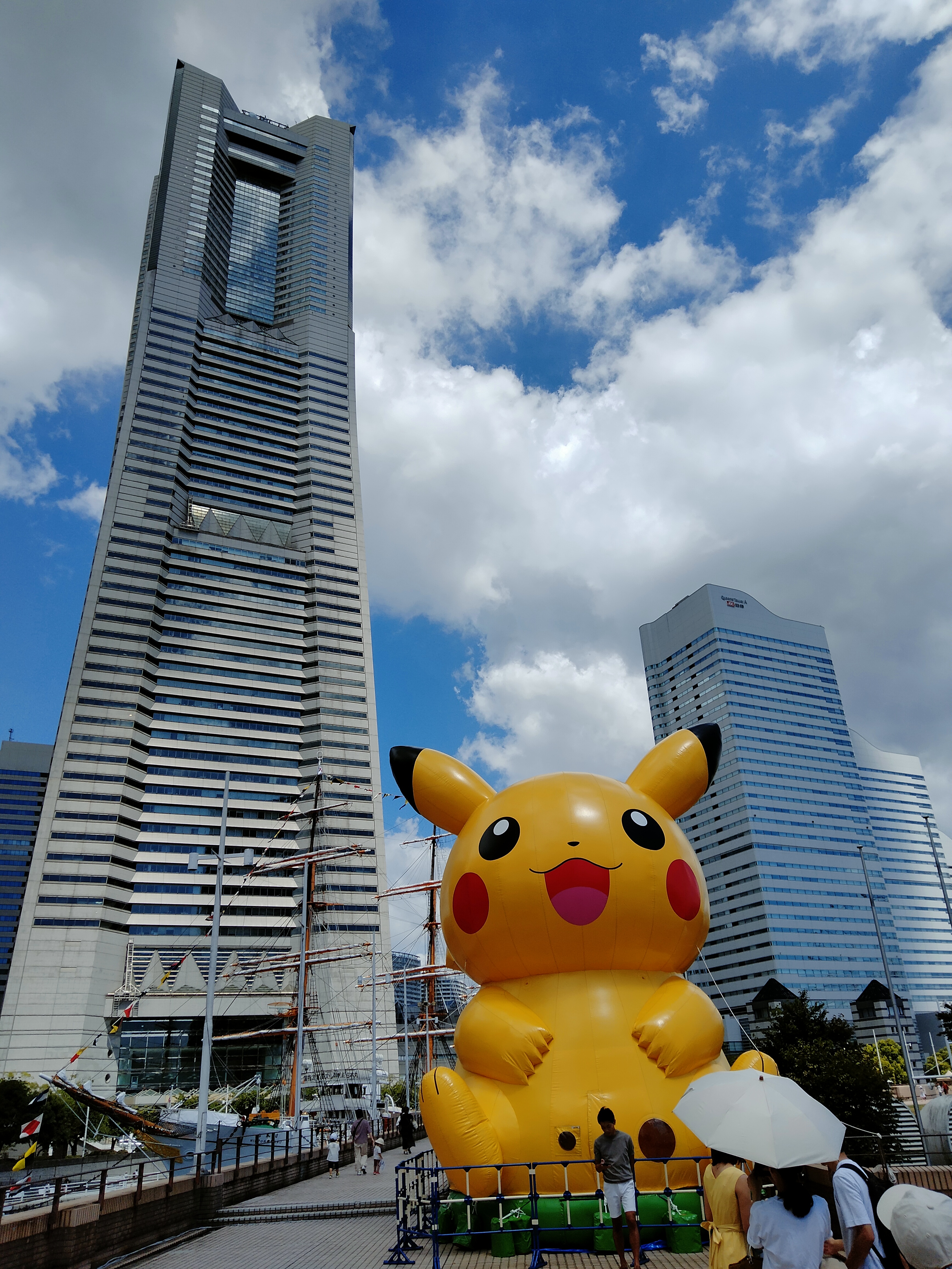 A giant inflatable Pikachu in front of the Yokohama Landmark Tower during the Pikachu Outbreak in Minato Mirai