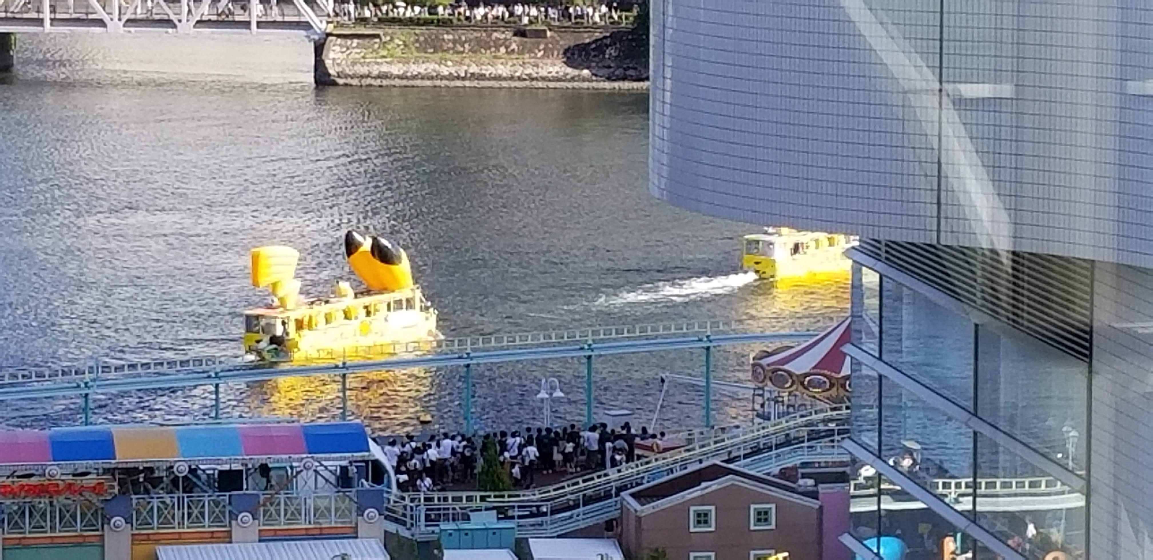A Pikachu-shaped boat sailing through Yokohama harbour during the Outbreak, with the crowd watching from the pier