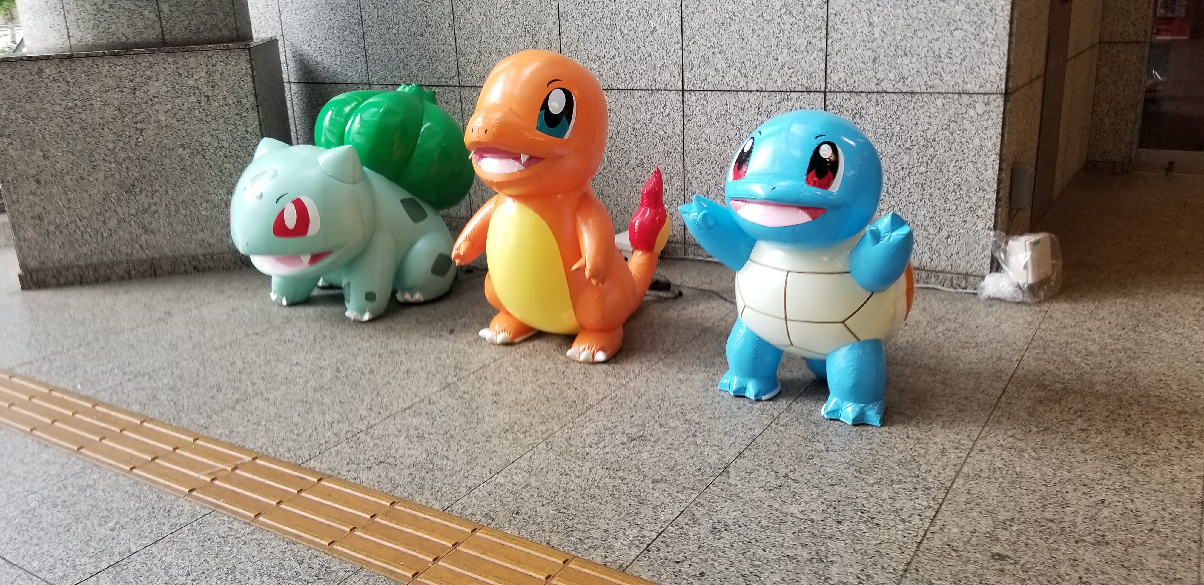 Bulbasaur, Charmander and Squirtle: figures of the three starter Pokémon on the streets of Yokohama during the event
