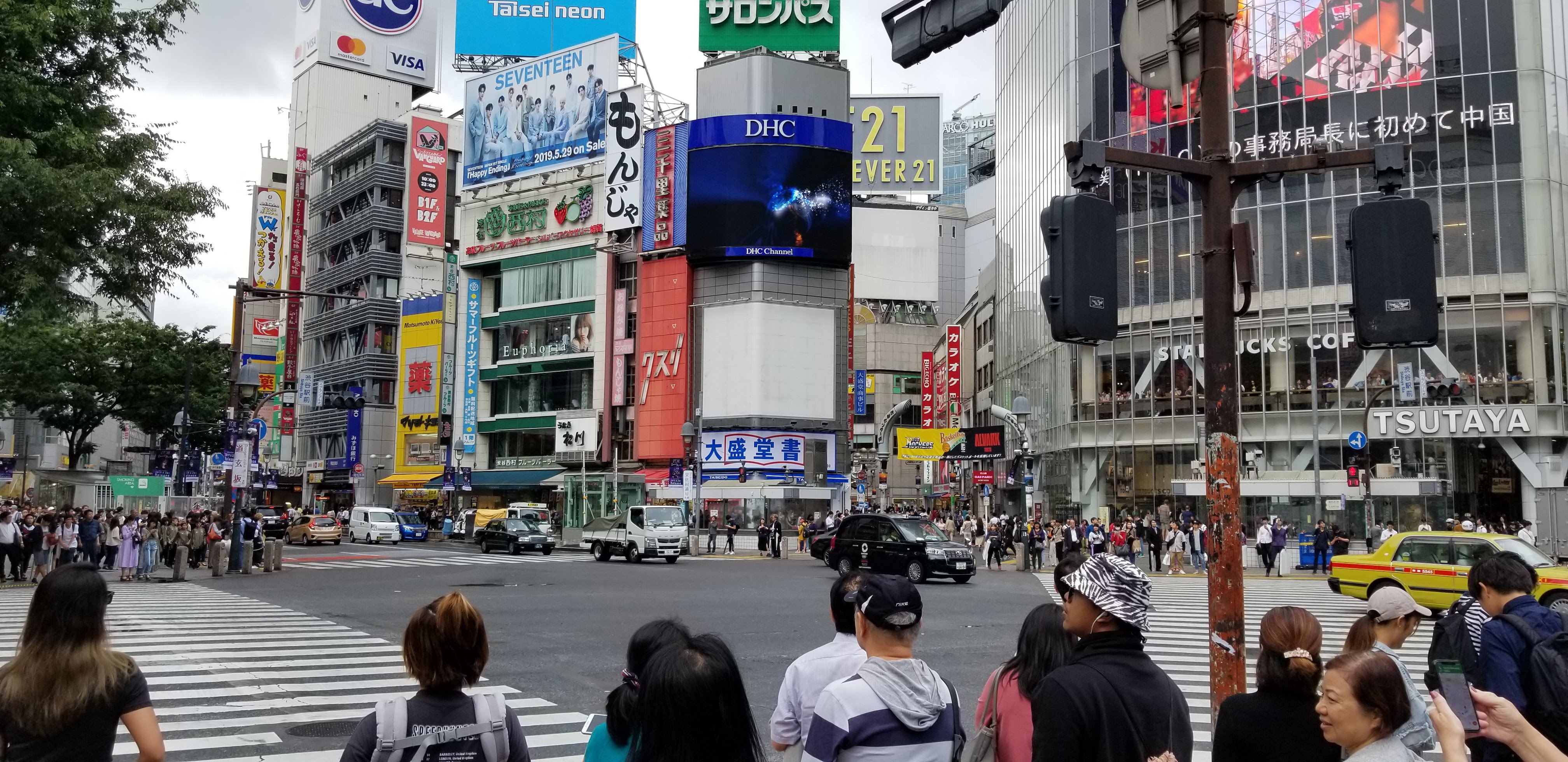 Shibuya Crossing during the day, with the Tsutaya building visible and crowds waiting to cross