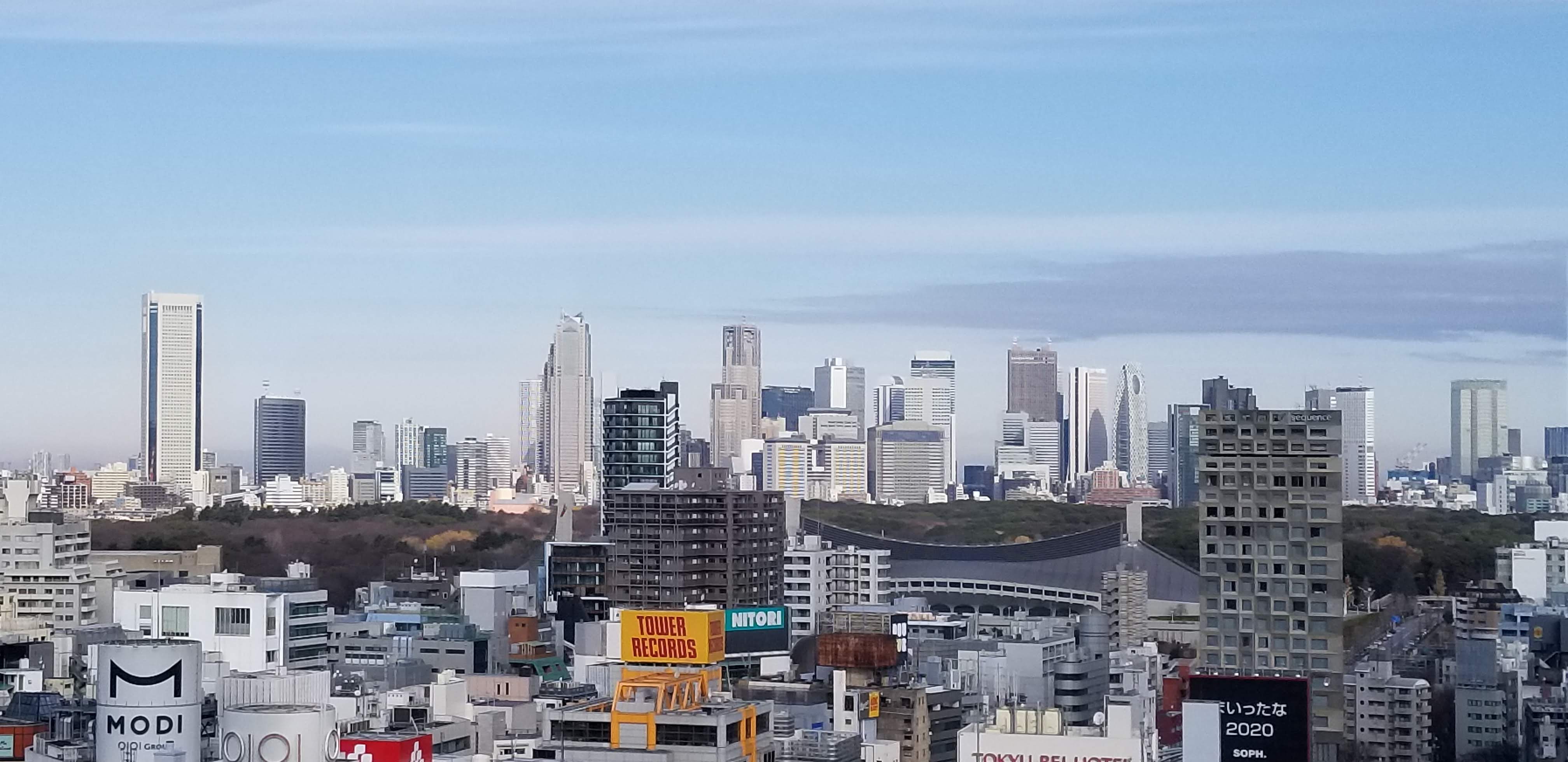 View from Shibuya Sky looking north, with Tower Records visible and the green of Shinjuku Gyoen in the distance
