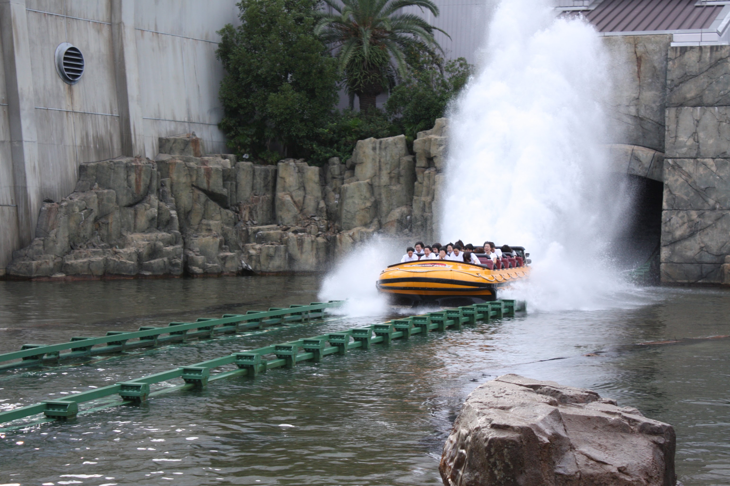 Boat at the final drop of Jurassic World — The Ride with a large water splash